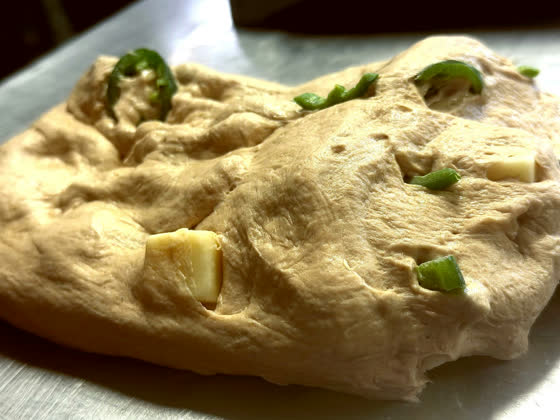Dough with cheese and jalapeno worked through it