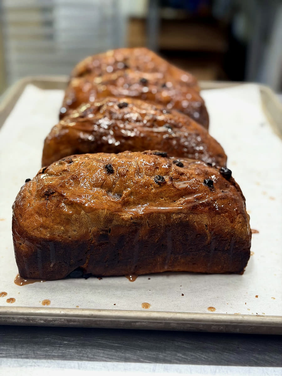 Finished glazed loaves cooling in a row after the bake