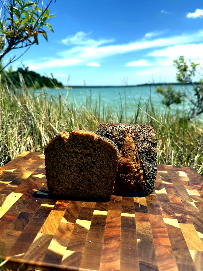 Two loaves side by side on a butcher block by the shore